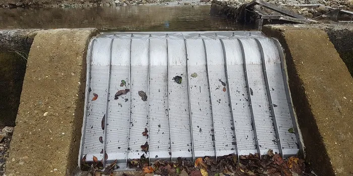 2 x ADENCO-70-0.75 Coanda-Einlaufrechen, 100 l/s Wasserfassung für Trinkwasser, breiter Coanda-Rechen zwischen Betonwänden mit Herbstlaub darauf, Draufsicht, Trabzon, Türkiye